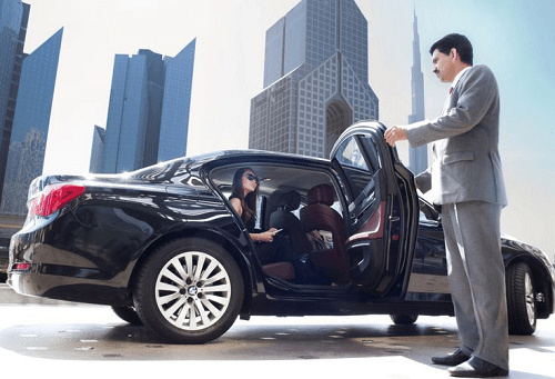 an image of a chauffeur opening the door for a passenger siting inside