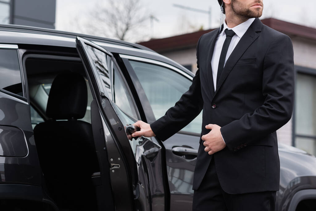 an image of a chauffeur opening the door for a passenger siting inside