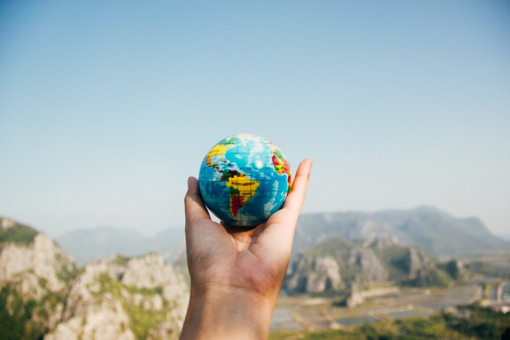 A person holding a small globe on his hand