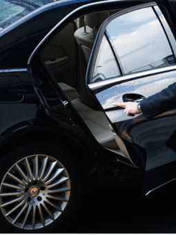 an image of a chauffeur opening the door for a passenger siting inside